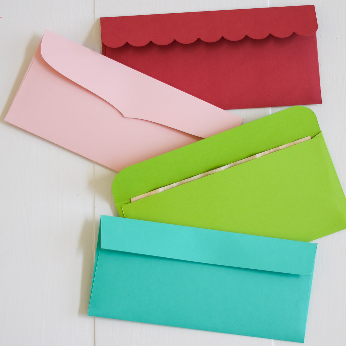 Four colorful envelopes (red, pink, green, and blue) on a light background
