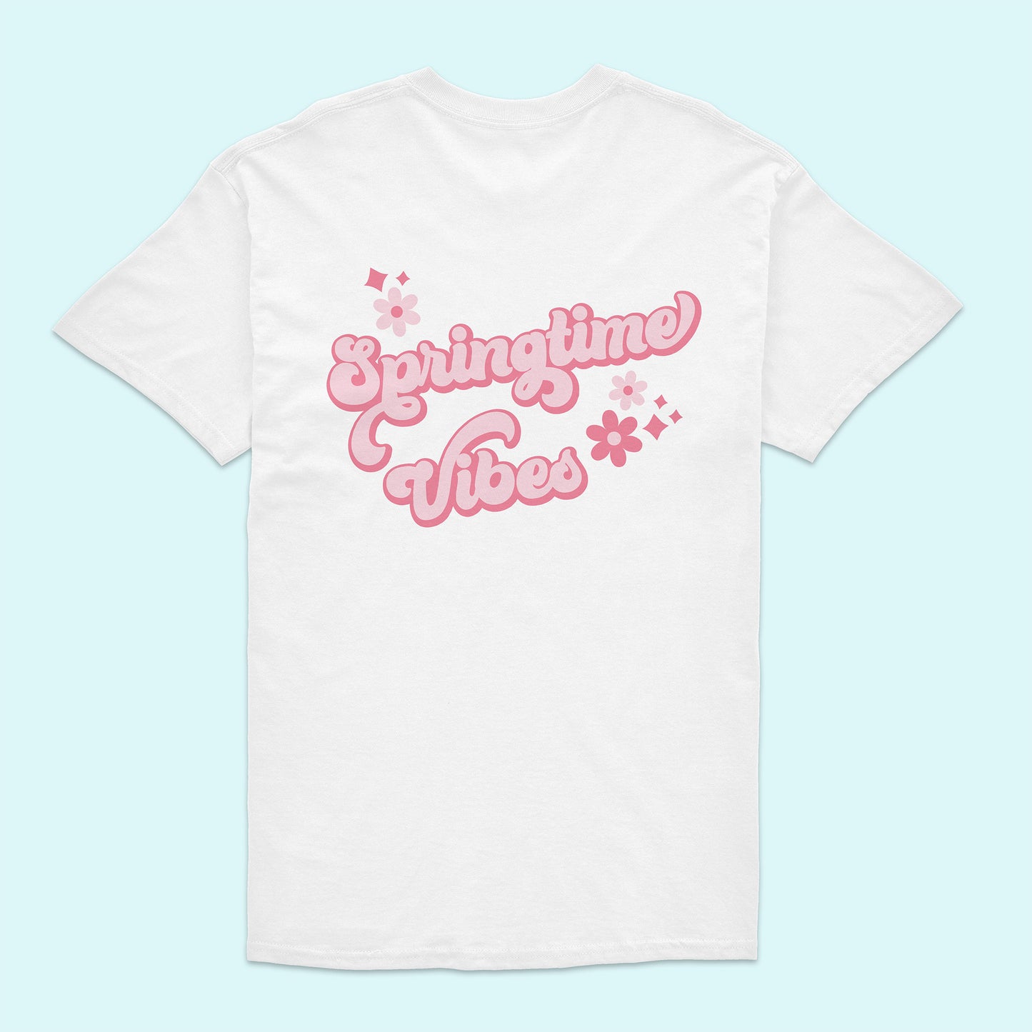 White t-shirt with 'Springtime Vibes' text in pink on a light blue background
