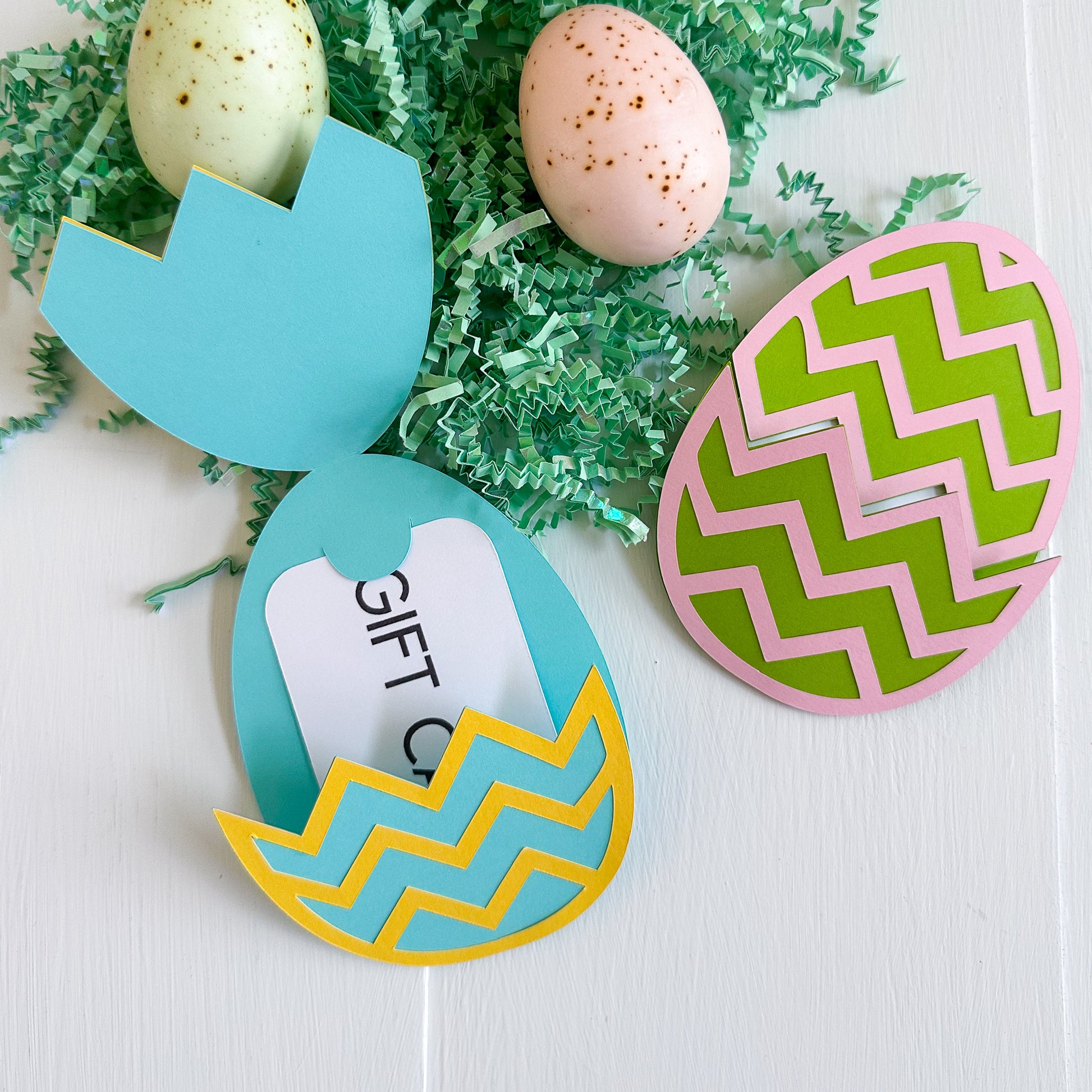 Colorful Easter egg-shaped gift card holders with decorative patterns on a white background.