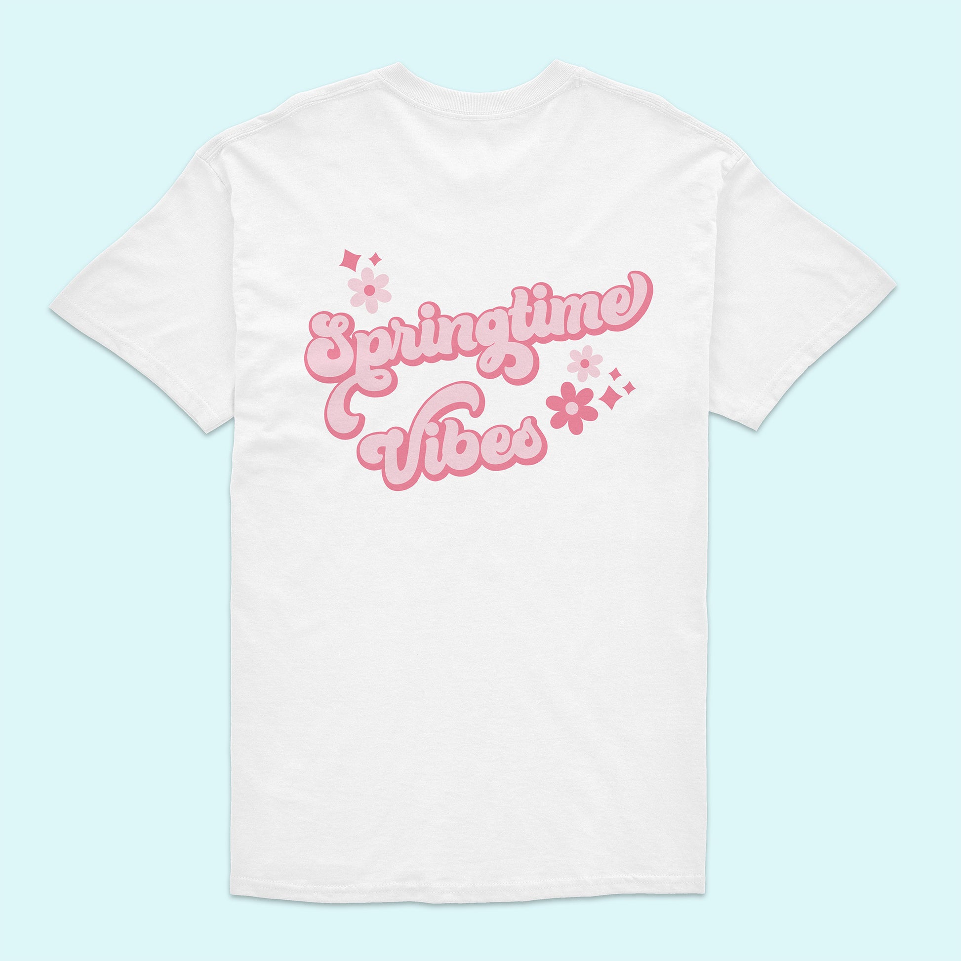 White t-shirt with 'Springtime Vibes' text in pink on a light blue background